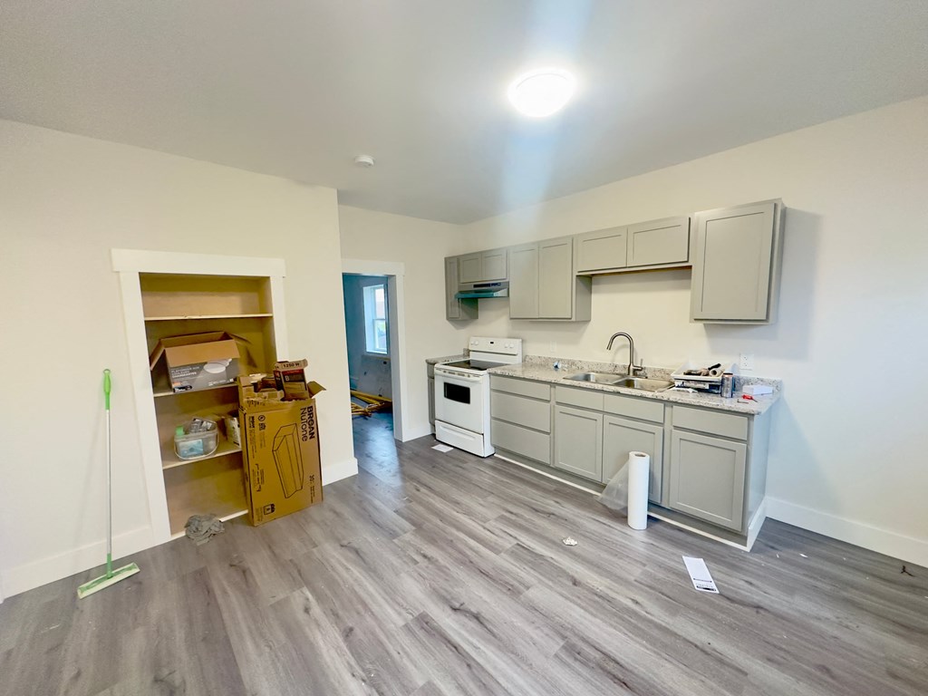 a kitchen is being remodeled with white cabinets and wood floors