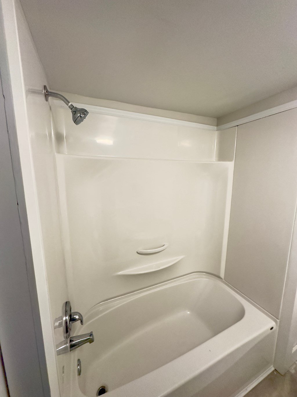 a white bathroom with a tub and a shower