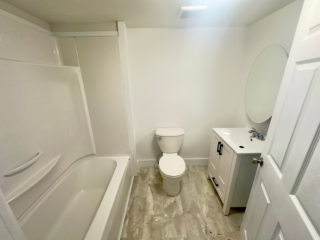 a bathroom with a toilet and a tub and a sink
