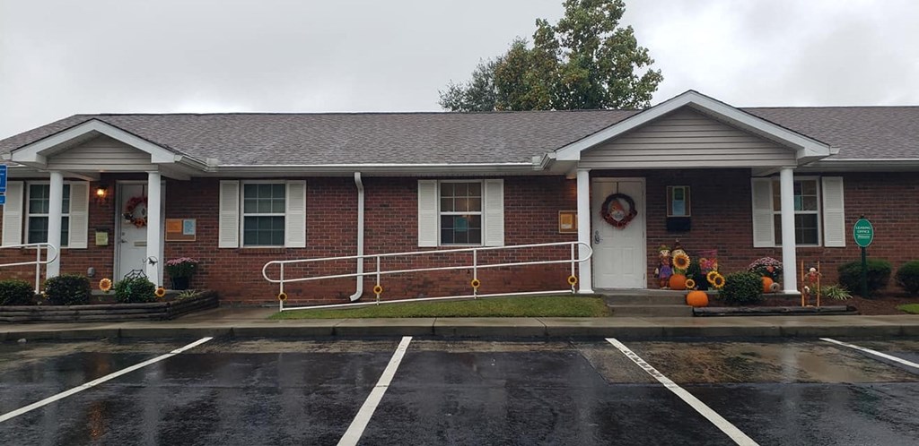 a red brick building with a porch and a rain
