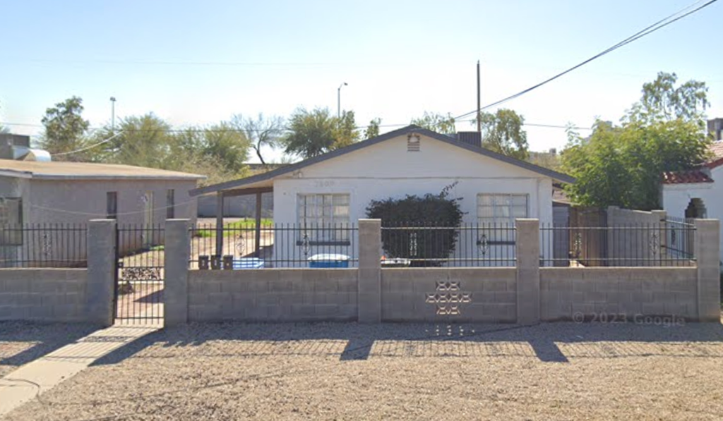 a house with a fence and a gate in front of it