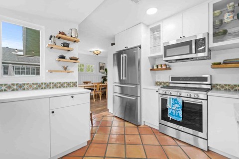 a kitchen with a refrigerator and a stove and a microwave