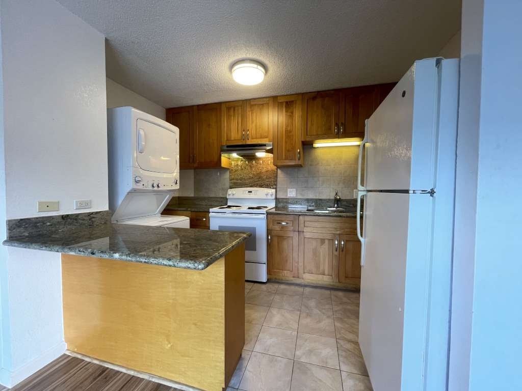 A kitchen with a white refrigerator, white oven, and a white microwave.