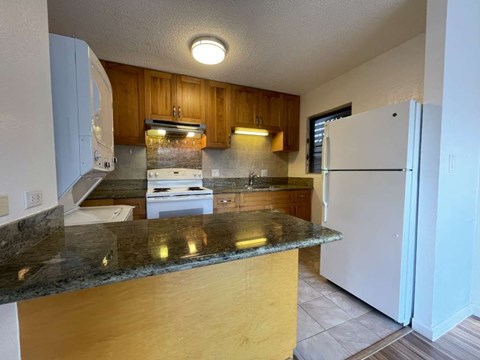 A kitchen with a white refrigerator and a counter top.
