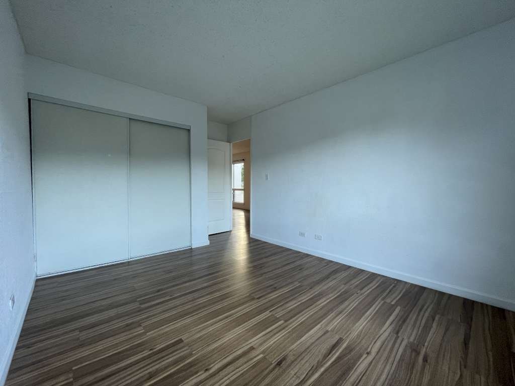 A room with wooden flooring and white walls.