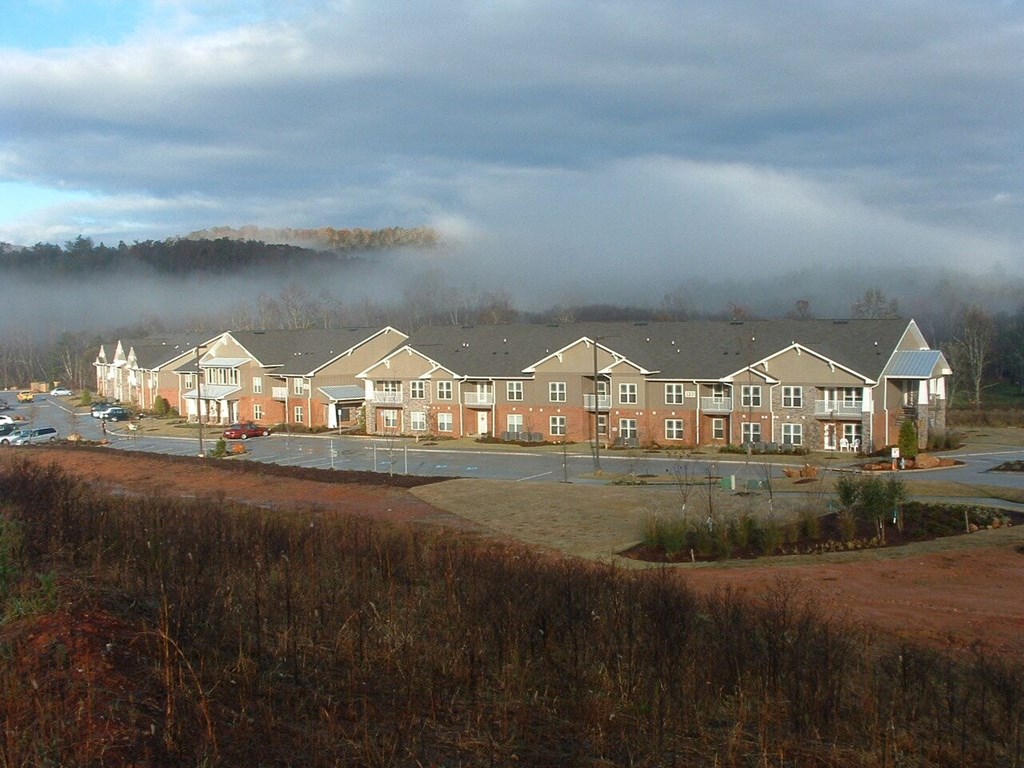 a row of houses with a foggy mountain in the background