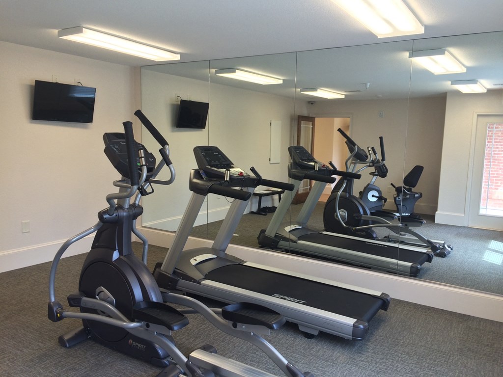 a gym with several exercise bikes and a tv