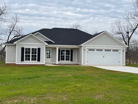 a white house with a yard and a garage door