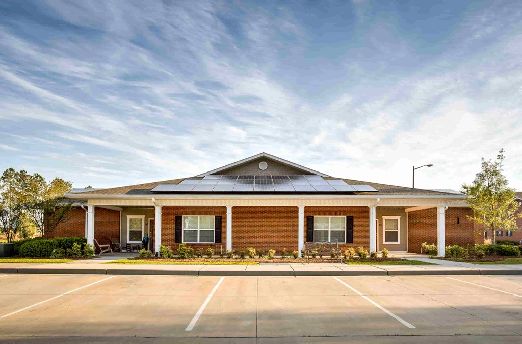 the front of a brick building with a parking lot