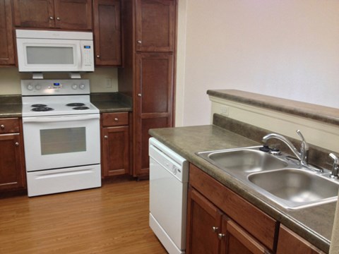 a kitchen with white appliances and wooden cabinets
