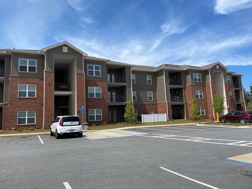 an apartment building with a car parked in a parking lot