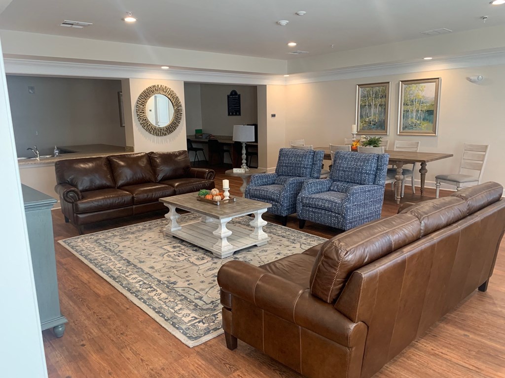a living room with leather couches and chairs and a table