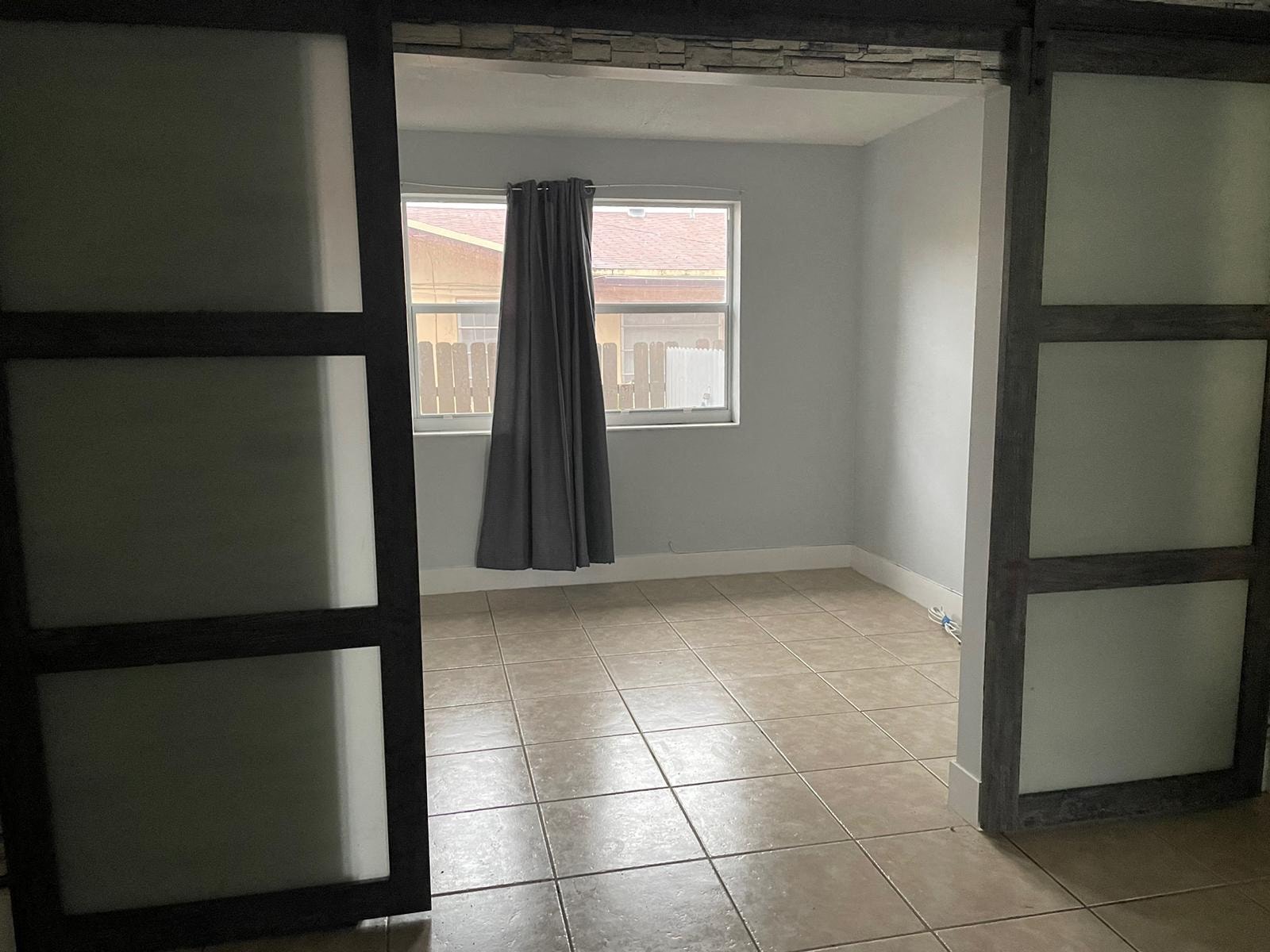 an empty room with a window and a curtain