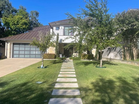 a house with a lawn and sidewalk in front of it