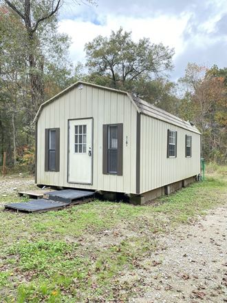 the exterior of a tiny house is shown with a ramp