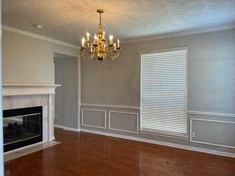 a living room with a fireplace and a chandelier