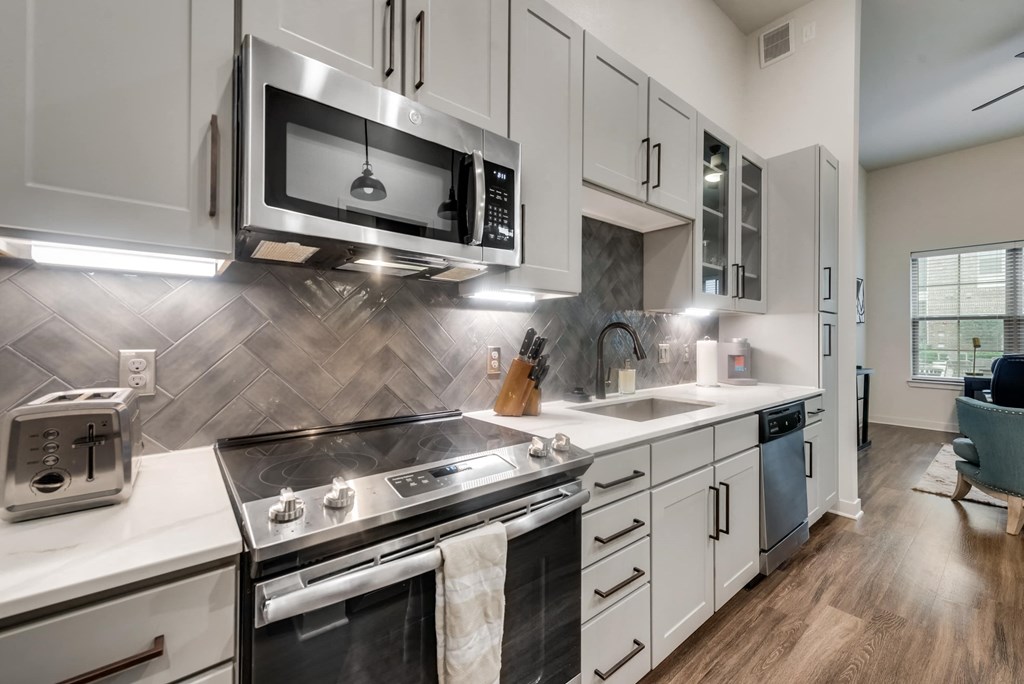 a kitchen with stainless steel appliances and white cabinets