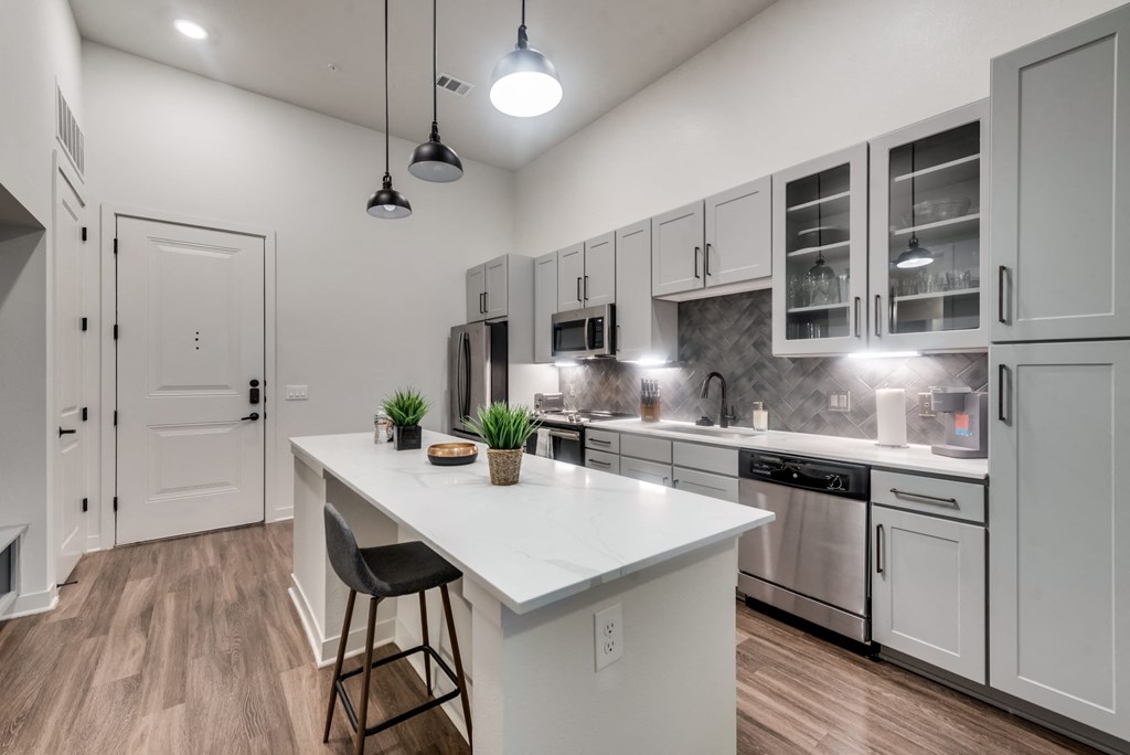 an open kitchen with white cabinets and a white counter top