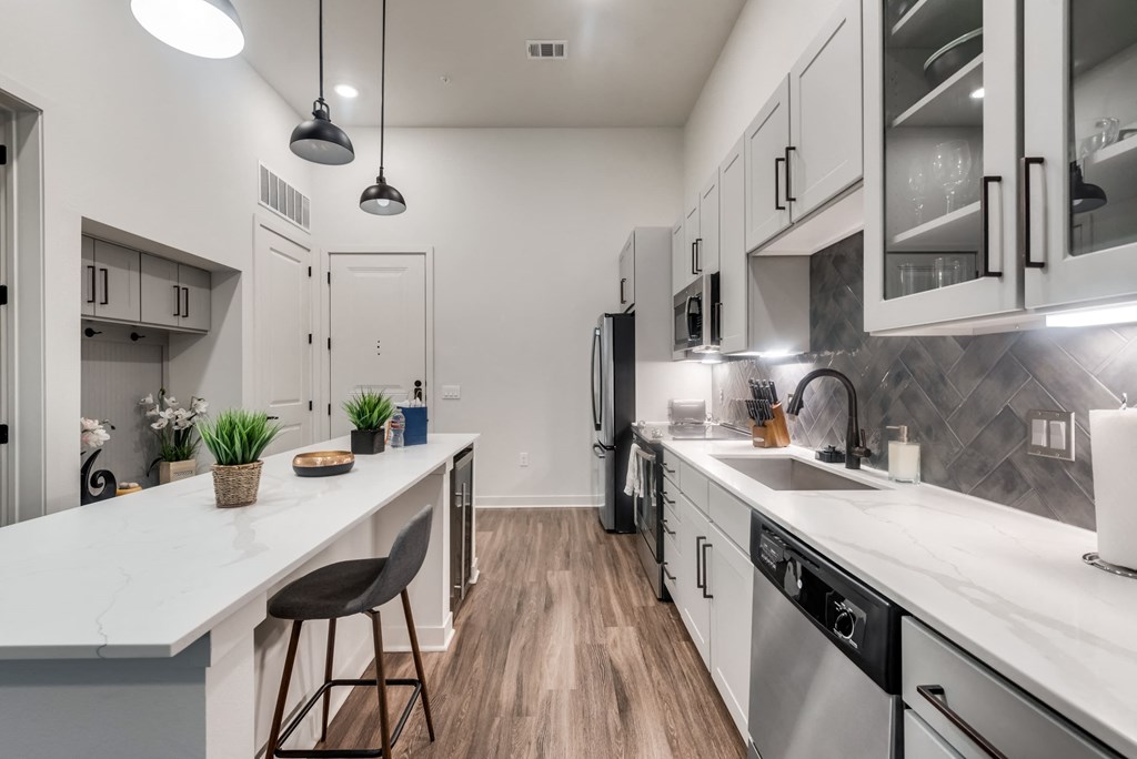 an open kitchen with white cabinets and a white counter top
