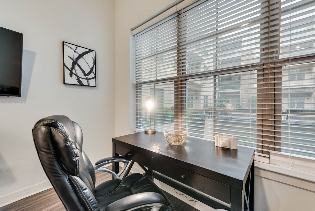 a office with a large window and a desk with a chair