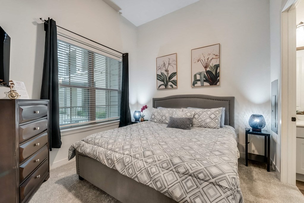 a bedroom with a bed and a large window