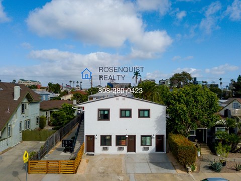 a view of a white building with a sign on top of it