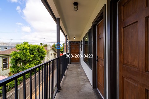 a balcony with a view of the street and a wooden door
