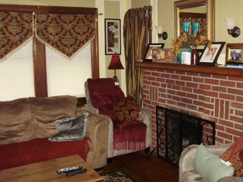 a living room with couches and a brick fireplace