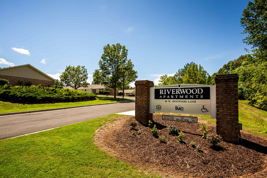 the sign for riverwood apartments in front of the street