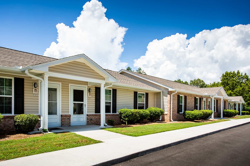 the front of a house with a sidewalk and grass
