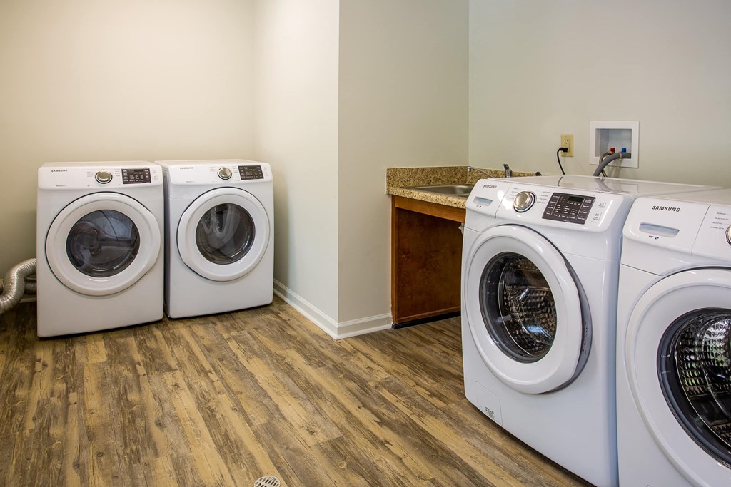 a washer and dryer in a laundry room with a counter and washing machines
