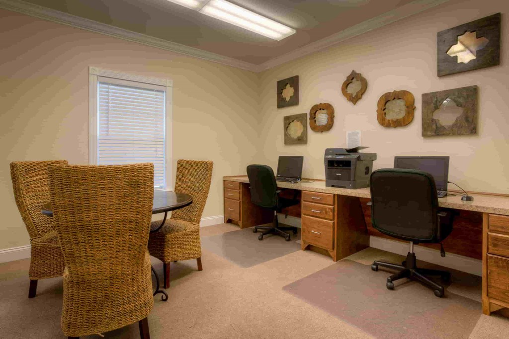 a home office with desks and chairs and a computer