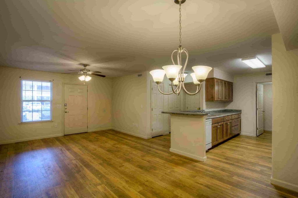 an empty kitchen and living room with a kitchen island and a window