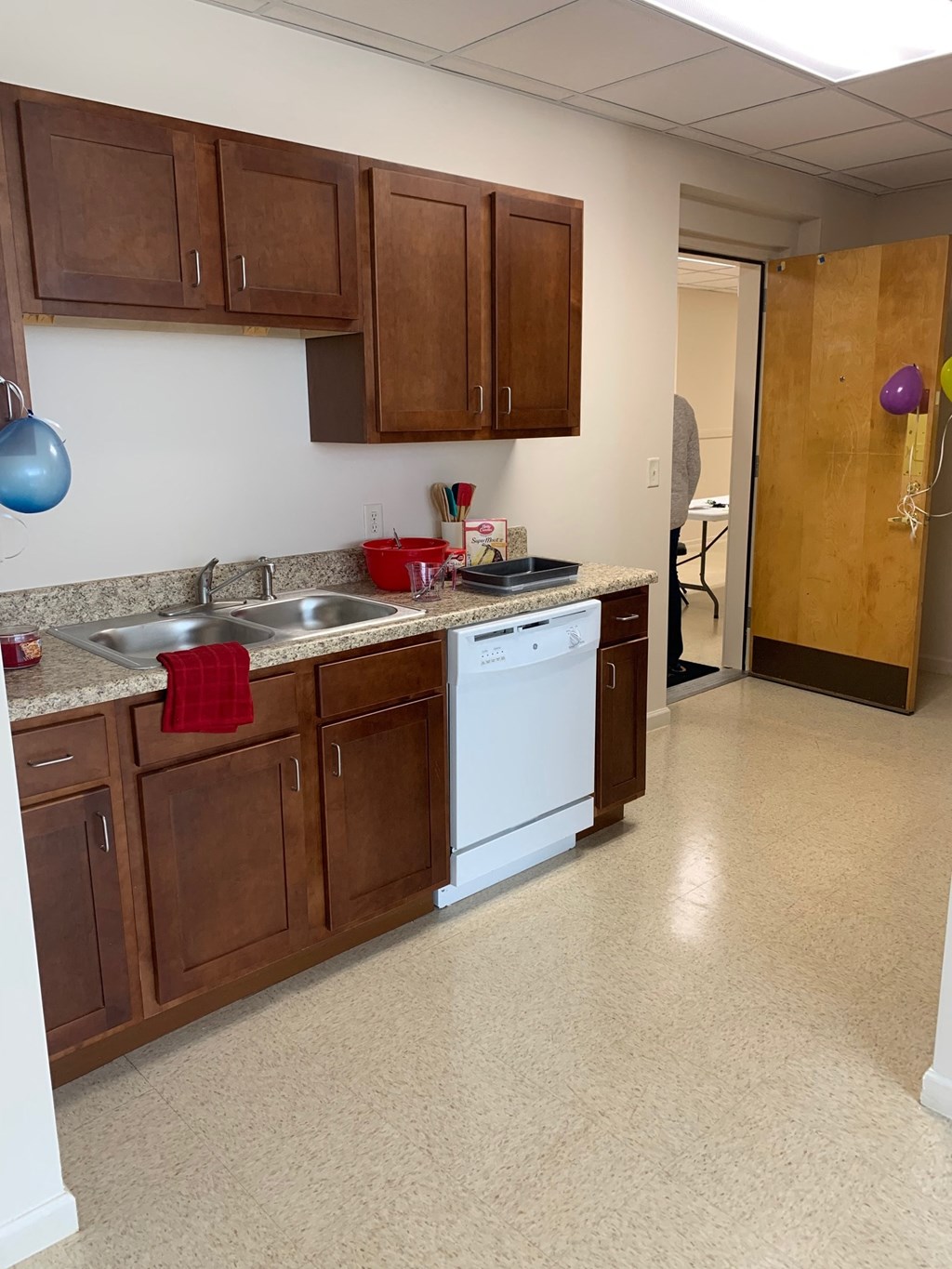 a kitchen with wooden cabinets and a white dishwasher