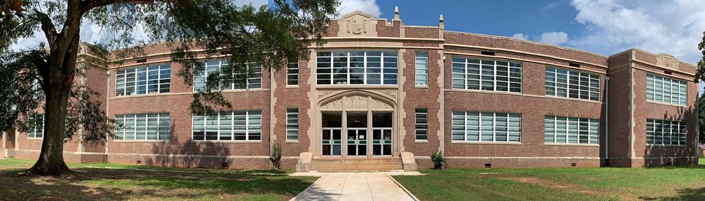 a large brick building with a tree in front of it