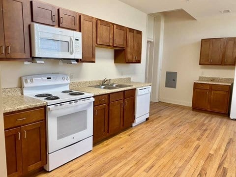 a kitchen with white appliances and wooden cabinets