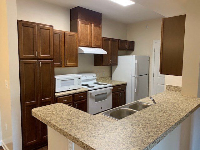 a kitchen with a granite counter top and white appliances