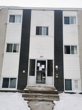 a white and black building with a door in the snow