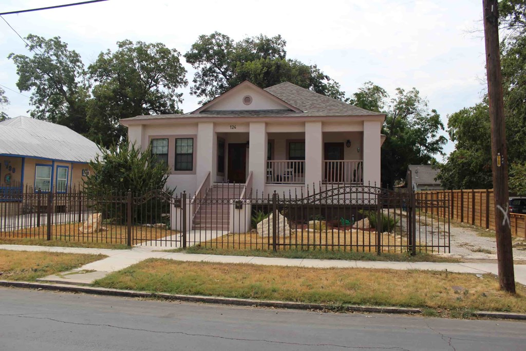 a house with a fence and a street in front of it
