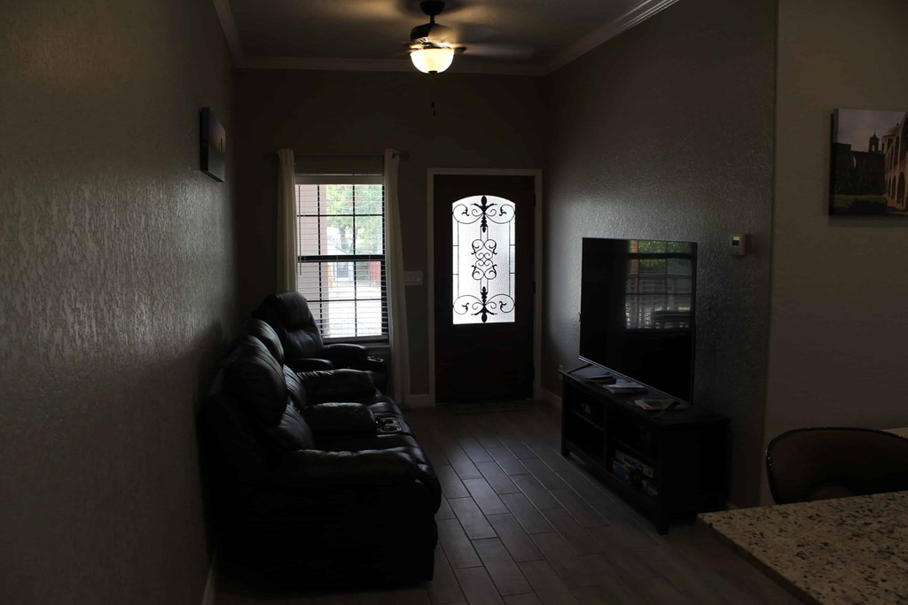 a dark living room with a couch and a tv