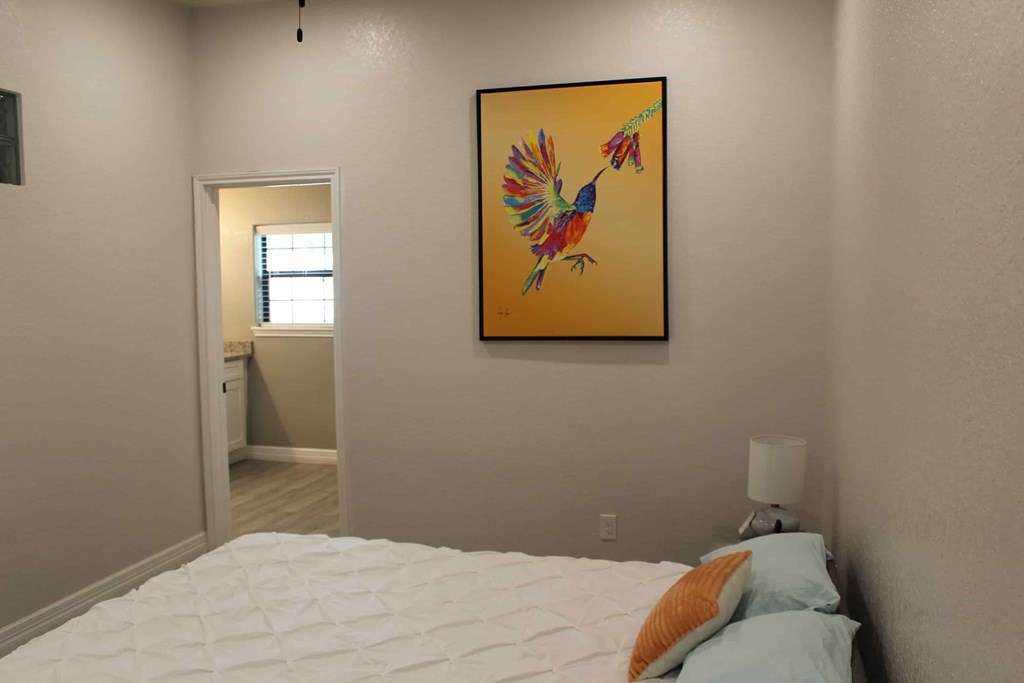 a bedroom with a bed and a painting of a bird