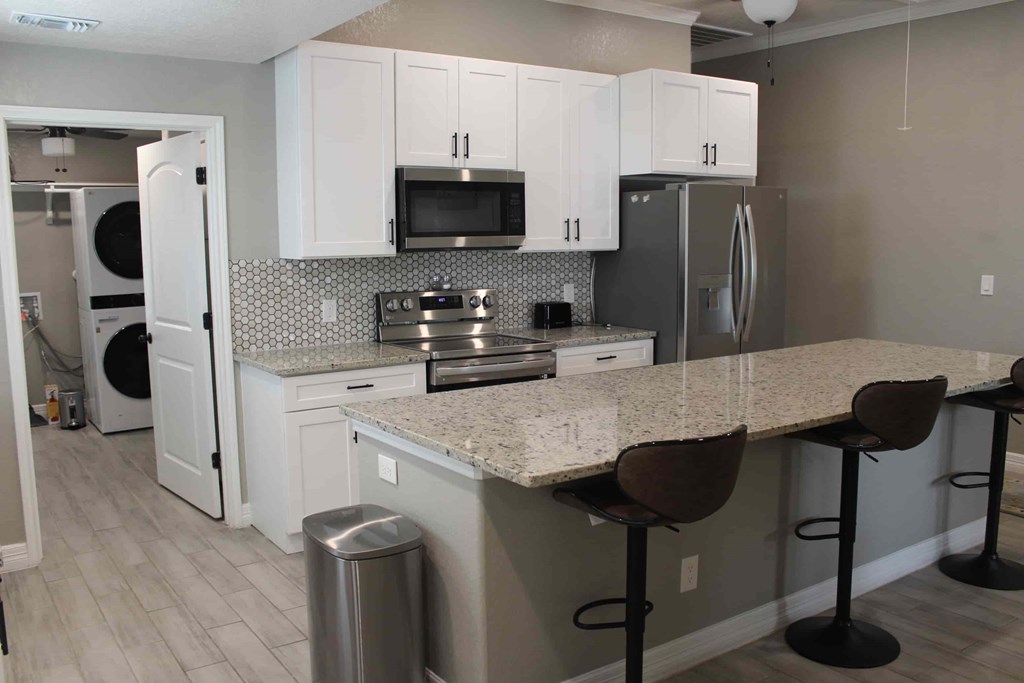 a kitchen with white cabinets and a counter top