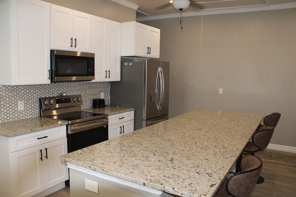 an updated kitchen with granite countertops and stainless steel appliances