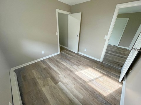 a living room with hardwood floors and a door to a closet