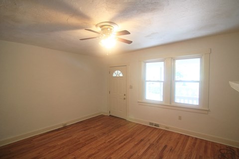 a bedroom with a ceiling fan and a door and a window