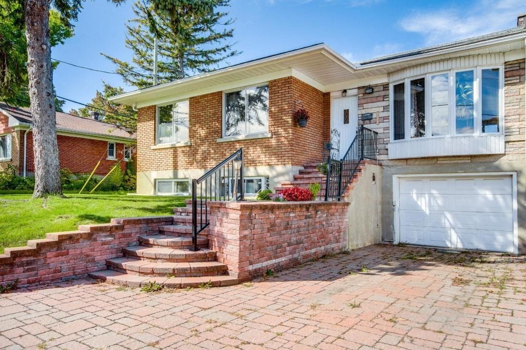 a brick house with a white garage door and a brick sidewalk