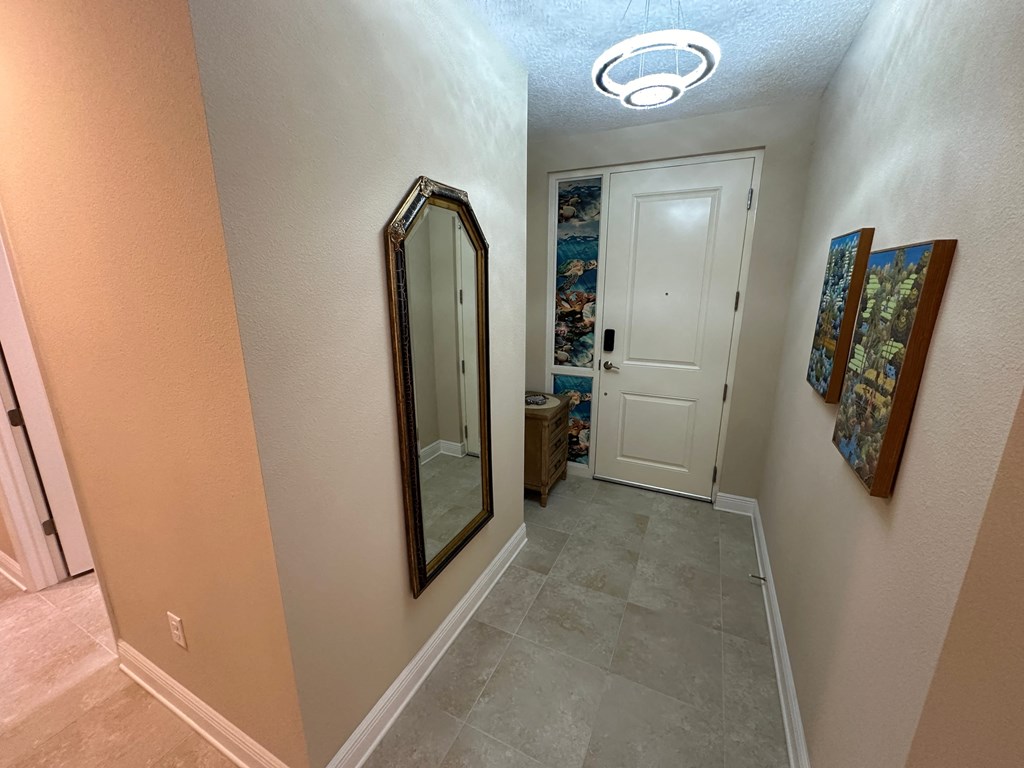 a hallway with a mirror and a door to a bathroom