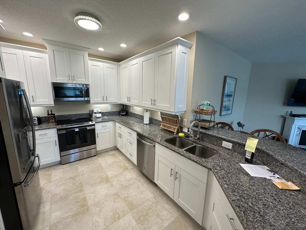 a kitchen with white cabinets and granite counter tops