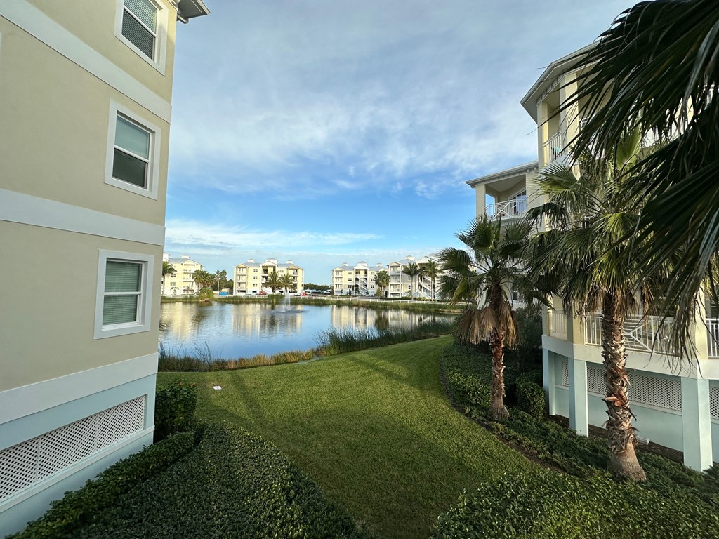 a view of the waterway between two apartment buildings with palm trees