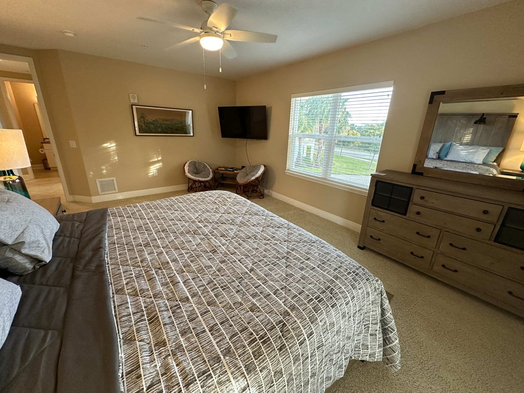 a bedroom with a bed and a dresser and a tv